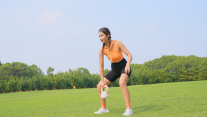 运动女性在草地上交叉训练挺举壶铃35秒视频