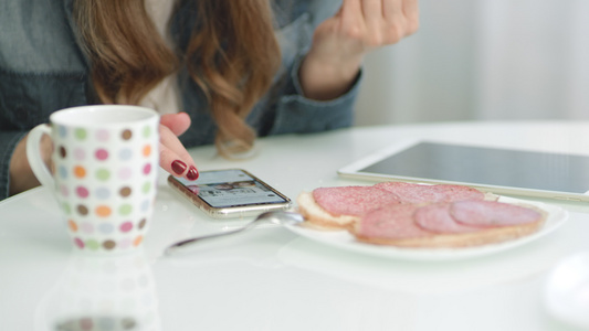 在厨房早餐时使用智能手机的紧视频