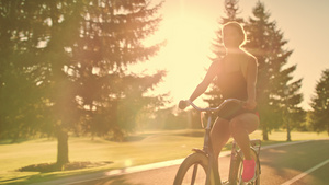 在金色日落风景的夏季公园骑自行车的健身妇女13秒视频