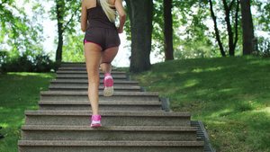 在夏日公园晨跑时上楼梯的健身女子24秒视频