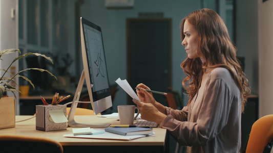 重点商业妇女,夜间在计算机屏幕上制作财务图表视频