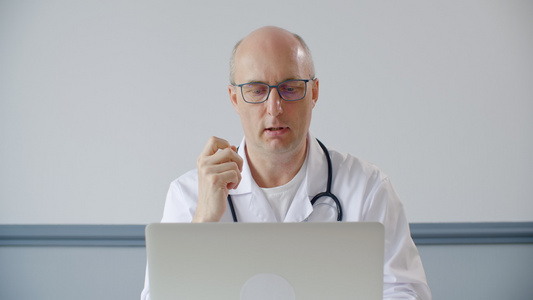 专业男医生持笔剪贴板并谈论诊断视频