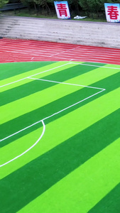 多角度航拍足球场上踢足球的学生绿茵场视频