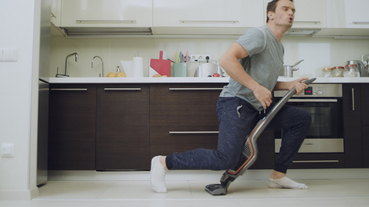 幸福的丈夫在现代厨房打扫地板视频