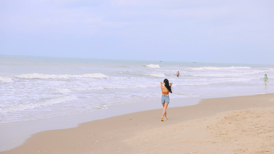 海边散步的青年女性[遛弯儿]视频