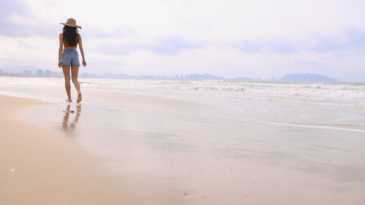 海滩上散步的女青年背影视频