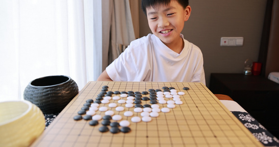 可爱的男孩在窗边下围棋视频