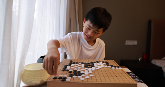 可爱的男孩在窗边下围棋视频