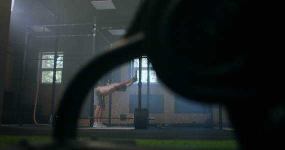 年轻的运动高加索男子在锻炼慢动作前在健身房更衣室换上举重带。用健身带将手臂绑在杠铃上视频