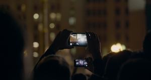 狂欢派对上的人举起手机拍摄18秒视频