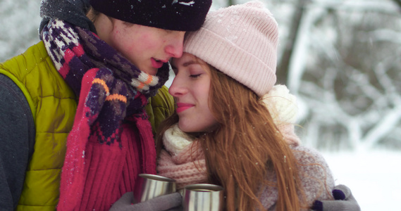 快乐的年轻夫妇在冬季雪地公园抱在一起视频