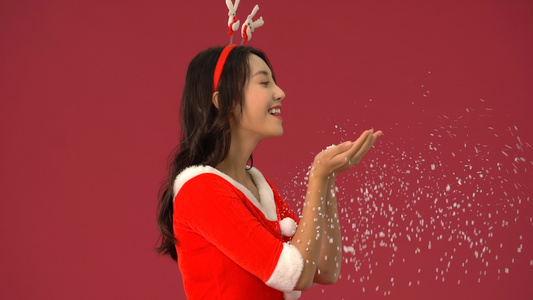 圣诞节女生吹起捧在手上的雪花视频