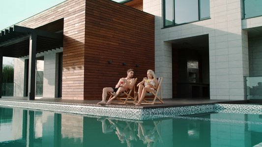 有钱夫妇在私人住宅游泳池附近放松视频