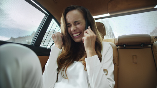 喜悦的女商人在现代汽车里用手机交谈视频