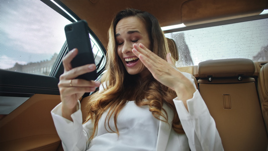 快乐的商务女士在业汽车上接到视频时得好消息的肖像视频