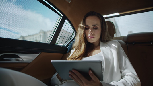 重点商业妇女阅读豪华轿车平板电脑的数据视频