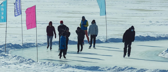 北方沈阳浑河冬季冰雪天地玩溜冰和打冰球的人们视频