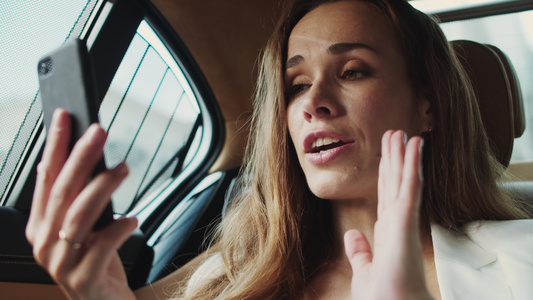 在现代汽车里用电话在视频聊天中交谈的焦躁商业女士肖像视频