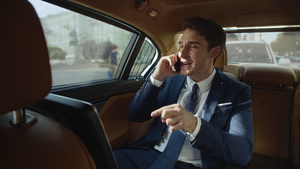 严格商人在豪华汽车的后座上在手机宣誓发15秒视频
