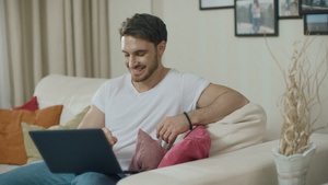 微笑的男人看着笔记本电脑16秒视频