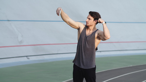 运动男子在田径场上自拍展示肌肉22秒视频