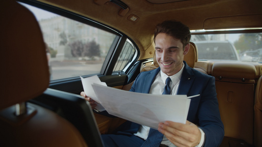 职业男性在车上看文件并露出微笑视频