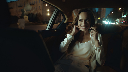 在黑暗的汽车里微笑着打电话的职业女性视频