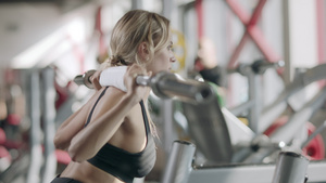 在健身中心用巴铃做蹲下锻炼的强健妇女10秒视频