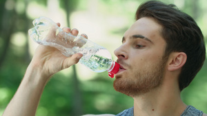 夏季公园酒瓶中喝水的人口渴10秒视频