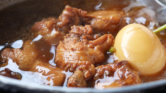 煮鸡蛋或鸡蛋和鸡肉,加调味料 在锅里的棕色酱汁。 传统塔伊美食视频