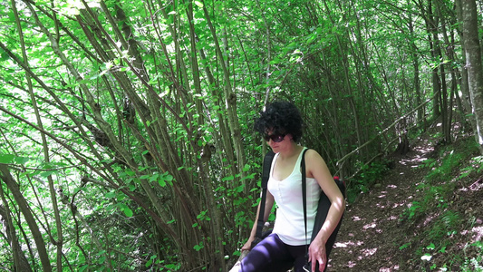 在绿林中行走享受大自然的美丽的年轻西班牙女生视频