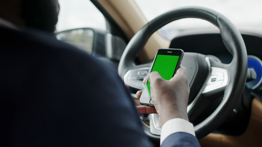 驾驶座男性使用绿色屏幕的手机触屏打字视频