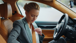 商务白领女性在驾驶座上系安全带26秒视频