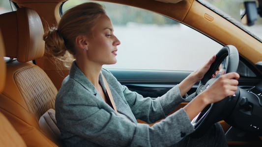 女性白领在汽车驾驶座上听歌左右摇摆舞动视频