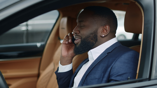 白领男性在汽车上使用手机交谈沟通视频