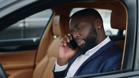 商务白领男性在汽车上使用手机交谈沟通视频