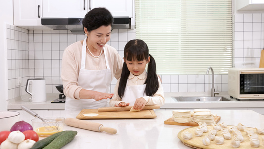 奶奶教孙女擀饺子皮视频