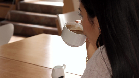 女孩在咖啡馆喝一小口咖啡视频