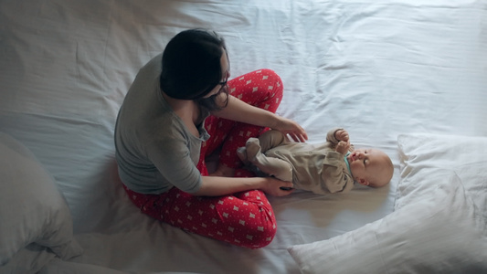 穿着睡衣和可爱孩子躺在床上的妇女视频