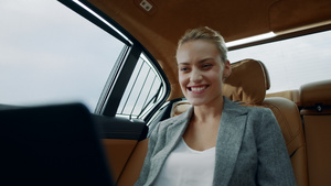 汽车后座白领女性用笔记本电脑收到好消息开心微笑17秒视频