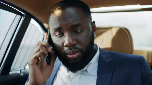 非洲商人在豪华轿车上谈论手机的热门话题视频