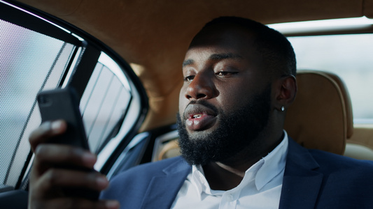 非洲商务男士在汽车上使用智能手机视频