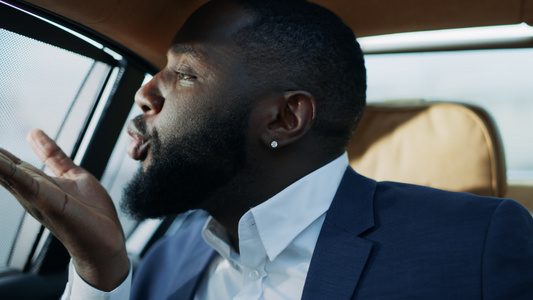 非洲商务男士肖像在汽车后座吹吻视频