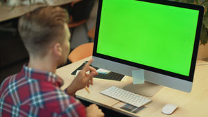 年轻人在办公室里用绿色屏幕在电脑上连线视频30秒视频