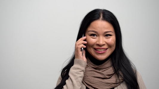 白人背景的美丽的亚洲女人 在电话上交谈。 (笑声)视频
