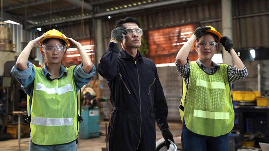 一群亚洲工厂男女工人戴着安全头盔视频