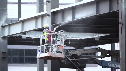 建筑工地工人对钢结构喷涂视频