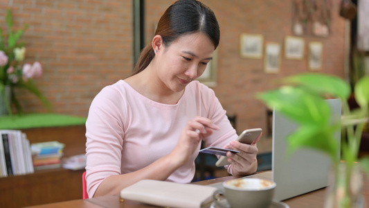 亚洲妇女使用信用卡在线购物送货上门。  之后的新常态生活。待在家里保持安全并保持社交距离视频