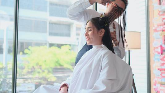 男美容院理发师给亚洲女人梳理长头发梳视频