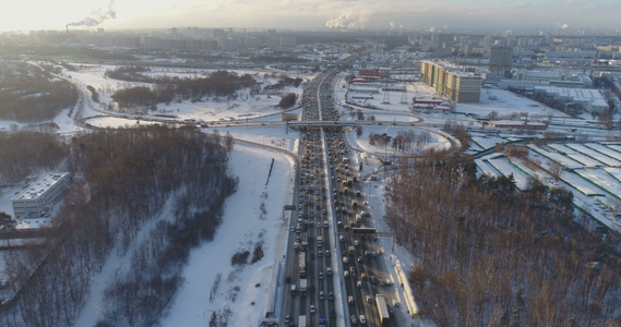 在阳光明媚的冬天寒冷的早晨在城市的高速公路上的汽车交通。城市景观。向前飞翔。鸟瞰图视频